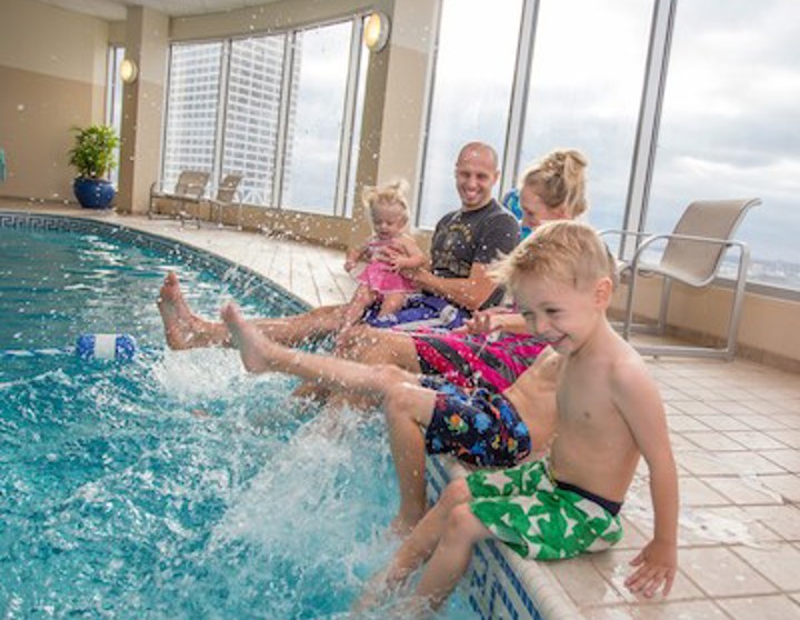 family splashing feet in pool